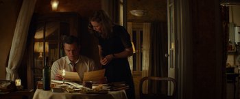 Movie still from “The Monuments Men” (2014), directed by George Clooney – A man and a woman sitting at a dinner table; Medium shot, Low angle