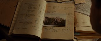 Movie still from “The Monuments Men” (2014), directed by George Clooney – An open book with a picture of a castle on it; Extreme Close Up shot, High angle