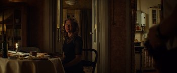 Movie still from “The Monuments Men” (2014), directed by George Clooney – A woman sitting at a table in front of a window; Medium shot, Over the shoulder angle