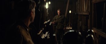 Movie still from “The Monuments Men” (2014), directed by George Clooney – A man standing in front of another man in a room; Medium shot, Over the shoulder angle