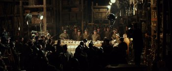 Movie still from “The Monuments Men” (2014), directed by George Clooney – A group of men in uniform sitting around a table; Wide shot, High angle