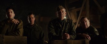 Movie still from “The Monuments Men” (2014), directed by George Clooney – A man in a military uniform is standing next to another man; Medium shot, Low angle