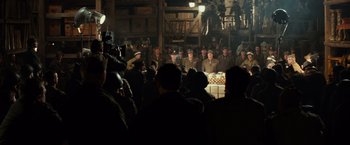 Movie still from “The Monuments Men” (2014), directed by George Clooney – A group of men in uniform sitting around a table; Wide shot, Over the shoulder angle