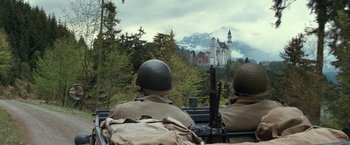 Movie still from “The Monuments Men” (2014), directed by George Clooney – Two men in military uniforms are looking out at a castle; Wide shot, Low angle