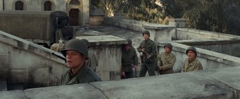 Movie still from “The Monuments Men” (2014), directed by George Clooney – A group of men standing next to each other on top of a building; Wide shot, High angle
