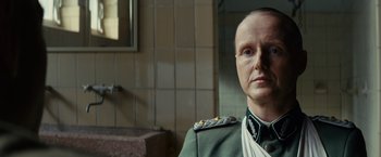 Movie still from “The Monuments Men” (2014), directed by George Clooney – A man in a military uniform sitting in front of a mirror; Close Up shot, Low angle