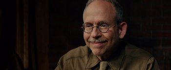 Movie still from “The Monuments Men” (2014), directed by George Clooney – An older man wearing glasses and a brown shirt; Close Up shot, Over the shoulder angle