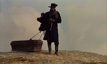 Movie still from “Django” (1966), directed by Sergio Corbucci – A man standing on top of a dirt hill; Wide shot, Low angle