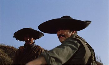 Movie still from “Django” (1966), directed by Sergio Corbucci – A couple of men wearing hats and standing next to each other; Medium shot, Low angle