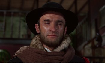 Movie still from “Django” (1966), directed by Sergio Corbucci – A man wearing a hat and a fur scarf; Close Up shot, Low angle