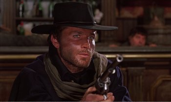 Movie still from “Django” (1966), directed by Sergio Corbucci – A man in a black hat holding a gun; Close Up shot, Low angle