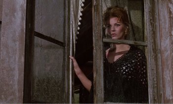 Movie still from “Django” (1966), directed by Sergio Corbucci – A woman in a black dress looking out of a window; Medium shot, Low angle