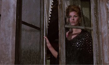 Movie still from “Django” (1966), directed by Sergio Corbucci – A woman in a black dress looking out of a window; Medium shot, Low angle