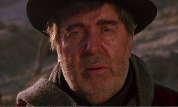 Movie still from “Django” (1966), directed by Sergio Corbucci – An older man wearing a black hat and a scarf; Close Up shot, Low angle