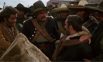 Movie still from “Django” (1966), directed by Sergio Corbucci – A group of men standing next to each other on top of a hill; Medium shot, Over the shoulder angle
