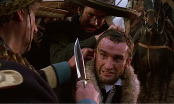Movie still from “Django” (1966), directed by Sergio Corbucci – A man is cutting another man's hair with a large knife; Close Up shot, Over the shoulder angle