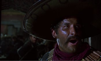 Movie still from “Django” (1966), directed by Sergio Corbucci – A man in a sombrero is looking into the camera; Close Up shot, Low angle