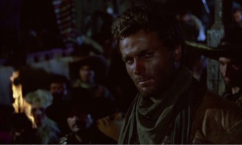 Movie still from “Django” (1966), directed by Sergio Corbucci – A person with a crowd in the background; Close Up shot, Over the shoulder angle