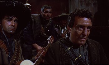 Movie still from “Django” (1966), directed by Sergio Corbucci – A group of men standing next to each other holding guitars; Medium shot, Over the shoulder angle