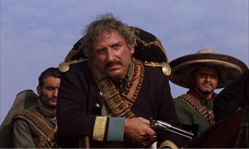 Movie still from “Django” (1966), directed by Sergio Corbucci – A man in a pirate costume holding a gun in his hand; Close Up shot, Low angle
