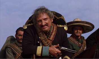 Movie still from “Django” (1966), directed by Sergio Corbucci – A man in a pirate costume holding a gun in front of two other men; Close Up shot, Low angle