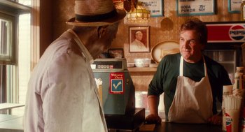 Movie still from “Do the Right Thing” (1989), directed by Spike Lee – Two men are standing at the counter of a restaurant; Medium shot, Over the shoulder angle