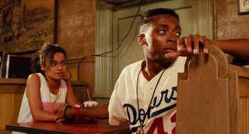 Movie still from “Do the Right Thing” (1989), directed by Spike Lee – A man sitting at a table with a woman; Close Up shot, Over the shoulder angle