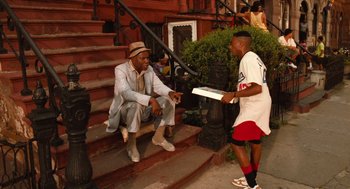 Movie still from “Do the Right Thing” (1989), directed by Spike Lee – Two men sitting on the steps of a house; Wide shot, Over the shoulder angle