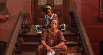 Movie still from “Do the Right Thing” (1989), directed by Spike Lee – A woman sitting on the ground next to another woman on the steps; Medium shot, Low angle