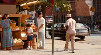 Movie still from “Do the Right Thing” (1989), directed by Spike Lee – A group of people standing on the side of a road; Wide shot, Over the shoulder angle