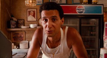 Movie still from “Do the Right Thing” (1989), directed by Spike Lee – A man in a white shirt is posing for a picture; Close Up shot, Low angle