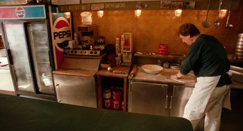 Movie still from “Do the Right Thing” (1989), directed by Spike Lee – A person standing in front of an oven in a kitchen; Wide shot, High angle