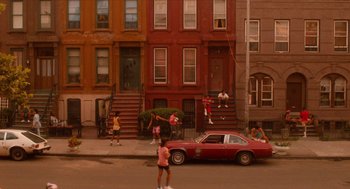 Movie still from “Do the Right Thing” (1989), directed by Spike Lee – A group of people standing on the side of a road; Extreme Wide shot, High angle