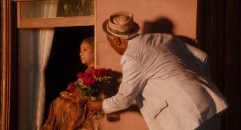 Movie still from “Do the Right Thing” (1989), directed by Spike Lee – A man and a woman holding flowers in front of a building; Medium shot, Over the shoulder angle