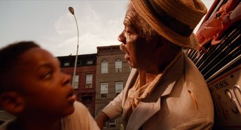 Movie still from “Do the Right Thing” (1989), directed by Spike Lee – An older man and a young boy in front of some buildings; Close Up shot, Low angle