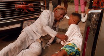 Movie still from “Do the Right Thing” (1989), directed by Spike Lee – An older man and a young boy are playing together; Medium shot, High angle
