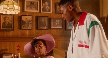 Movie still from “Do the Right Thing” (1989), directed by Spike Lee – A man and a woman standing next to each other in a room; Close Up shot, Over the shoulder angle