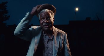 Movie still from “Do the Right Thing” (1989), directed by Spike Lee – An older man wearing a suit and a hat; Close Up shot, Low angle