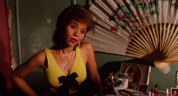 Movie still from “Do the Right Thing” (1989), directed by Spike Lee – A woman in a yellow top sitting in front of a fan; Close Up shot, High angle