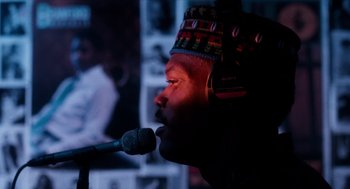 Movie still from “Do the Right Thing” (1989), directed by Spike Lee – A man with a microphone wearing a colorful hat; Close Up shot, Low angle