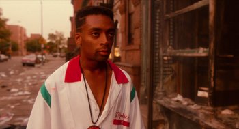 Movie still from “Do the Right Thing” (1989), directed by Spike Lee – A man in a red and white shirt standing in front of a brick building; Close Up shot, Low angle