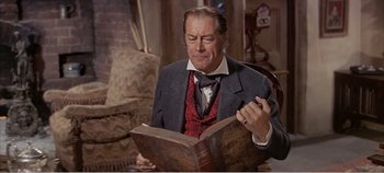 Movie still from “Doctor Dolittle” (1967), directed by Richard Fleischer – A man in a suit is looking at an old book; Close Up shot, Low angle