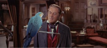 Movie still from “Doctor Dolittle” (1967), directed by Richard Fleischer – A man in a suit and tie standing next to a parrot; Close Up shot, Over the shoulder angle