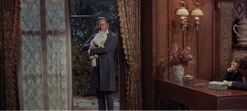 Movie still from “Doctor Dolittle” (1967), directed by Richard Fleischer – A man holding a white cat in his arms; Medium shot, Over the shoulder angle
