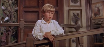Movie still from “Doctor Dolittle” (1967), directed by Richard Fleischer – A young boy sitting on top of a wooden railing; Medium shot, High angle