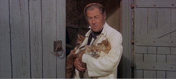 Movie still from “Doctor Dolittle” (1967), directed by Richard Fleischer – A man holding two small dogs in his arms; Medium shot, Over the shoulder angle