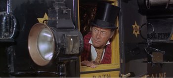 Movie still from “Doctor Dolittle” (1967), directed by Richard Fleischer – A man wearing a top hat looking out of a train window; Medium shot, Over the shoulder angle