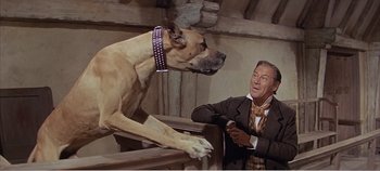 Movie still from “Doctor Dolittle” (1967), directed by Richard Fleischer – A man in a suit and tie with a large dog; Medium shot, Low angle