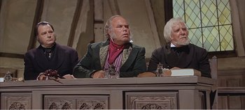 Movie still from “Doctor Dolittle” (1967), directed by Richard Fleischer – A man sitting in front of two other men; Medium shot, High angle