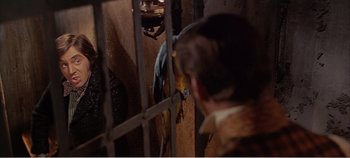 Movie still from “Doctor Dolittle” (1967), directed by Richard Fleischer – A man looking through the bars of a jail cell; Medium shot, Over the shoulder angle